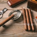 Cuban cigars on wooden background, top view